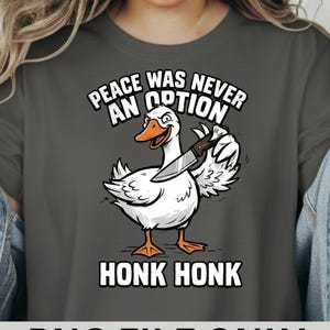 May include: Dark grey t-shirt with a cartoon goose brandishing a knife, the text above reads "PEACE WAS NEVER AN OPTION" and "HONK HONK" below. The bottom of the shirt reads "PNG FILE ONLY".