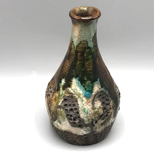 May include: A handcrafted ceramic vase with a textured surface. The vase features a dark brown base that transitions to a green and turquoise upper portion. The vase has a unique, organic shape and a crackle glaze.