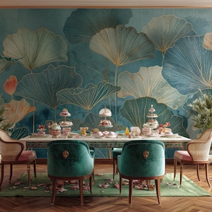 Op de afbeelding: Een eetkamer met een lange witte tafel gedekt voor een theeparty. De tafel is omringd door groene fluwelen stoelen en stoelen met roze kussens. De achtergrond is een turquoise muurschildering met gouden bloemmotieven. Onder de tafel ligt een groen tapijt.