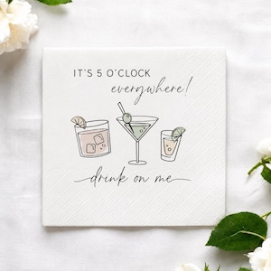 May include: A white square paper napkin featuring a black line drawing of three cocktails, including a rocks glass, a martini glass with an olive, and a shot glass. The text reads IT'S 5 O'CLOCK everywhere! and drink on me in black ink.