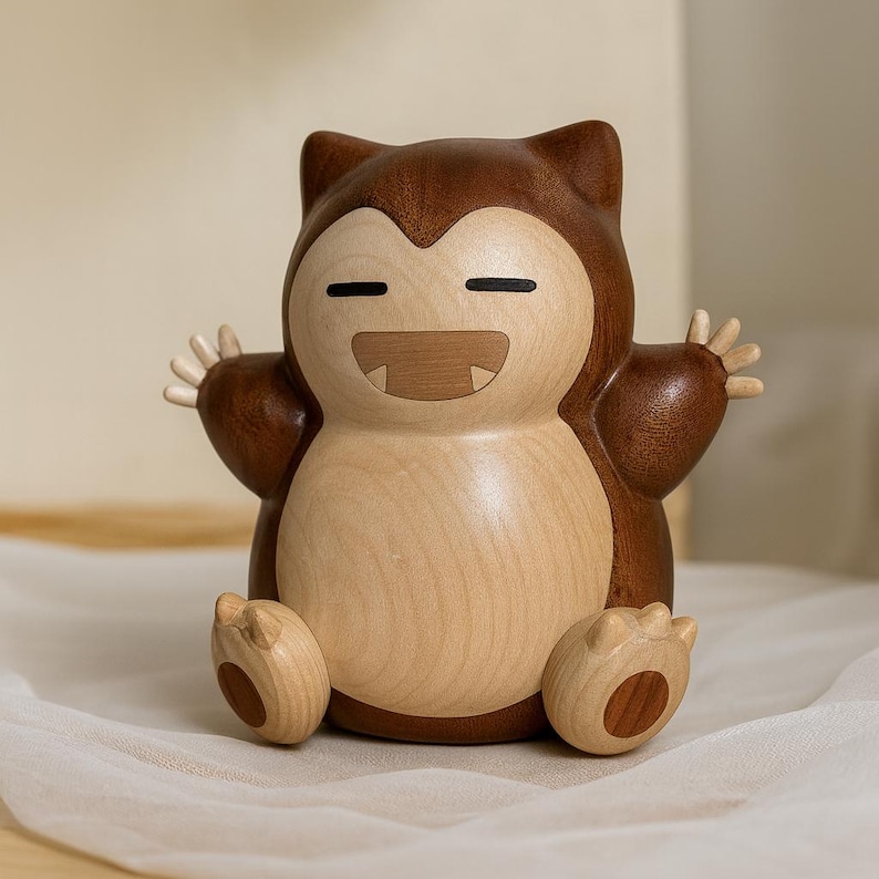 May include: A wooden Snorlax figurine with a light brown body and dark brown accents. The figurine has a smiling expression with its arms and legs outstretched. The wood grain is visible, adding to its handcrafted appearance.