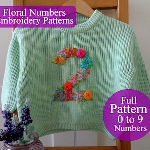 Może przedstawiać: Jasnozielony sweter z haftowanym kwiatami numerem 2 na środku. Haft przedstawia kolorowe kwiaty w odcieniach różu, pomarańczy, błękitu i żółci. Tekst na zdjęciu brzmi "Floral Numbers Embroidery Patterns" i "Full Pattern 0 to 9 Numbers."