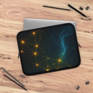May include: A black laptop sleeve with a celestial design. The design features a network of gold lines and glowing orbs against a dark blue and teal background. The sleeve has a black zipper and a black border.