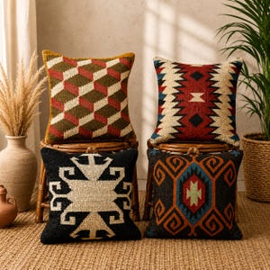 Puede incluir: Cuatro cojines decorativos cuadrados con diseños geométricos y tribales. Los cojines presentan una variedad de colores, incluyendo rojo, marrón, negro y azul. Parecen estar hechos de tela tejida.