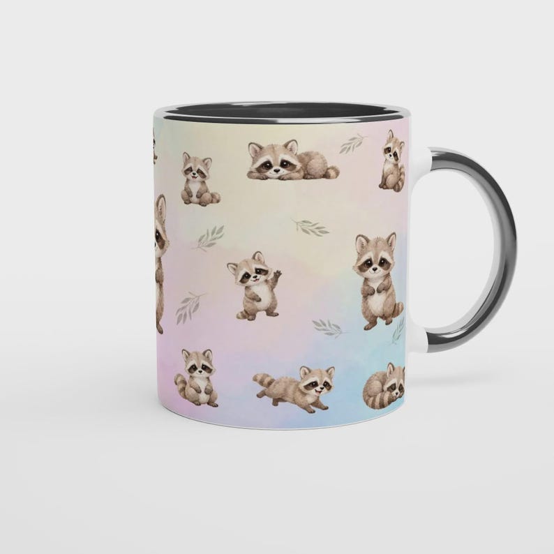 May include: A ceramic mug with a black interior and handle, featuring a repeating watercolor-style pattern of small brown and grey raccoons in various poses, including sitting, standing, and lying down, set against a soft pastel gradient background.
