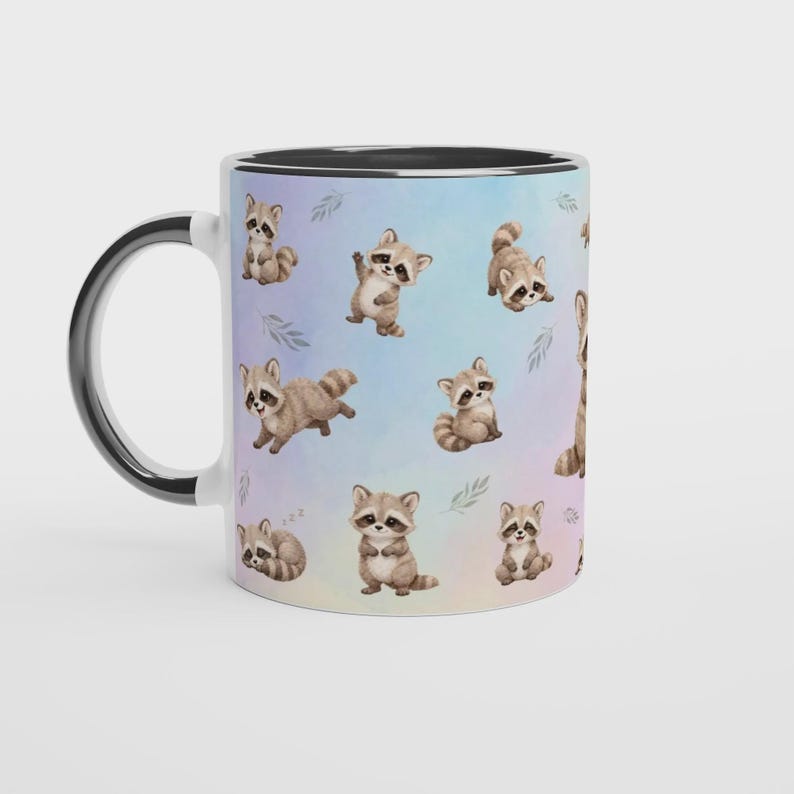 May include: A ceramic mug with a black handle and interior, featuring a repeating pattern of illustrated brown and grey raccoons in various poses against a soft, pastel-colored watercolor background with small green leaf accents.