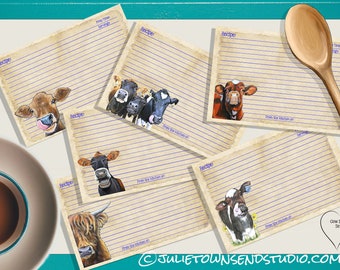 May include: A set of rectangular recipe cards with a vintage paper texture, blue lined writing spaces, and illustrations of various cows. Each card features the text Recipe, Prep Time, Servings, and From the kitchen of. A wooden spoon is included.