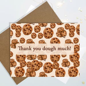 May include: A greeting card with a brown kraft paper envelope. The card features a pattern of chocolate chip cookies and the text "Thank you dough much!" in a brown font. The card is on a white surface.