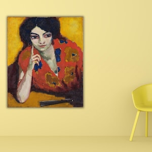 Puede incluir: Pintura al óleo de una mujer con cabello oscuro y una prenda estampada en rojo y dorado. La pintura está en una pared amarilla, con una silla amarilla a la derecha. Un abanico negro está en primer plano.