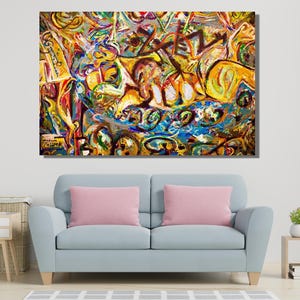 Puede incluir: Pintura expresionista abstracta con una vibrante mezcla de colores, incluyendo amarillo, azul, rojo y verde. La obra presenta pinceladas y formas dinámicas, creando una sensación de movimiento y energía. La pintura se exhibe sobre un sofá azul claro con cojines rosas.