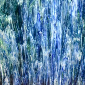 May include: Abstract glass art piece with a flowing, watery design. The artwork features a blend of blues, greens, and white, creating a dynamic and textured visual effect. The colors swirl and blend, evoking a sense of movement.