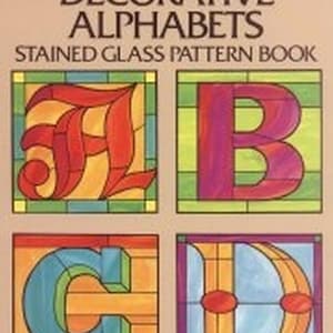 Könnte beinhalten: Buchcover mit dem Titel "Decorative Alphabets Stained Glass Pattern Book" von Ed Sibbett Jr. Zeigt farbenfrohe Glasmalerei-Buchstabenentwürfe: A in Rot und Gelb, B in Lila, C in Blau und Orange und D in Orange und Blau.
