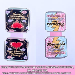 May include: Four decorative can-shaped stickers. Two feature a black background with a red heart and the text "Dark Romance - Forbidden Cherry." The other two have a light blue background with a gold lightning bolt and the text "Enemies to Lovers."