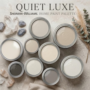 Op de afbeelding: Een verzameling verfblikken in diverse neutrale kleuren, waaronder gebroken wit, beige en grijs, gerangschikt op een getextureerd oppervlak. De tekst "QUIET LUXE" en "Sherwin-Williams. HOME PAINT PALETTE" zijn zichtbaar. Kristallen en gedroogde planten zijn ook aanwezig.