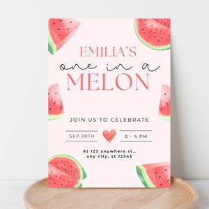Puede incluir: Una tarjeta de invitación rosa con rodajas de sandía y el texto "EMILIA'S one in a MELON". La tarjeta incluye el texto "JOIN US TO CELEBRATE", la fecha, la hora y la dirección.