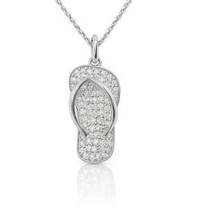 May include: A silver pendant necklace featuring a flip-flop design. The flip-flop is encrusted with small, sparkling stones. The pendant hangs from a delicate silver chain, creating a piece of jewelry suitable for casual or formal wear.