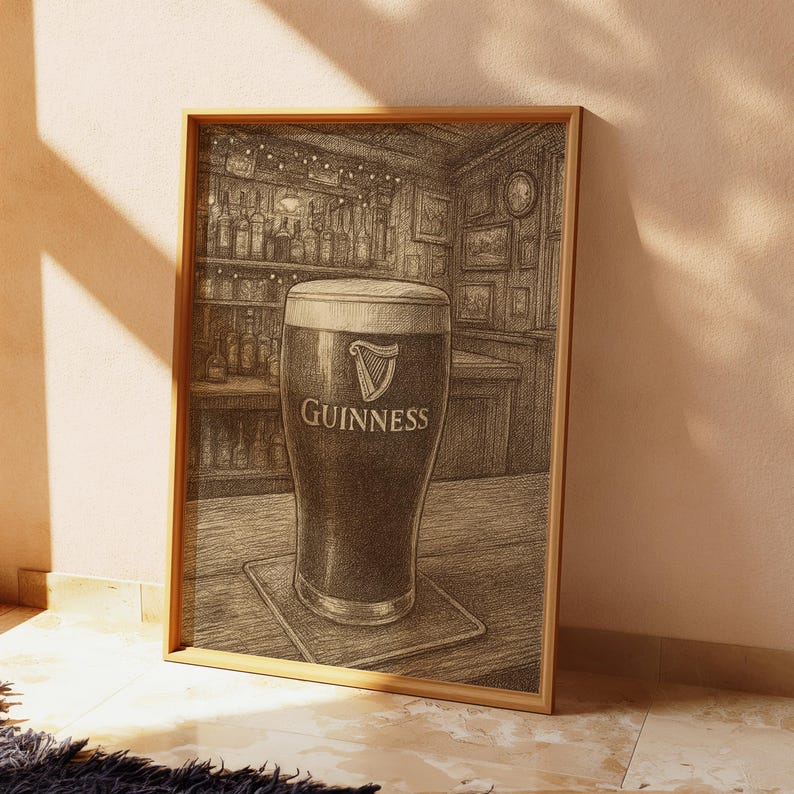 May include: A framed print of a pint of Guinness stout in a pub setting. The glass is filled with dark beer and a creamy head, with the Guinness logo visible. The background shows a bar with bottles and framed pictures.