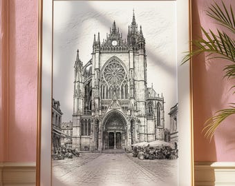 May include: Framed black and white architectural print of a cathedral. The detailed drawing depicts the cathedral's facade, including a rose window, spires, and arched entrance. The print is in a gold frame, displayed against a pink wall.