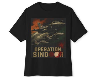 Puede incluir: Una camiseta negra de manga corta con un estampado gráfico de tres aviones de combate volando a través de un cielo oscuro y nublado. Debajo de los aviones, el texto OPERATION SINDOOR aparece en letras mayúsculas grandes de color beige con un acento rojo.