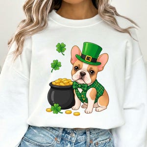 May include: White sweatshirt featuring a cartoon French Bulldog wearing a green plaid vest, bow tie, and leprechaun hat. A black pot of gold coins and shamrocks complete the St. Patrick's Day design.