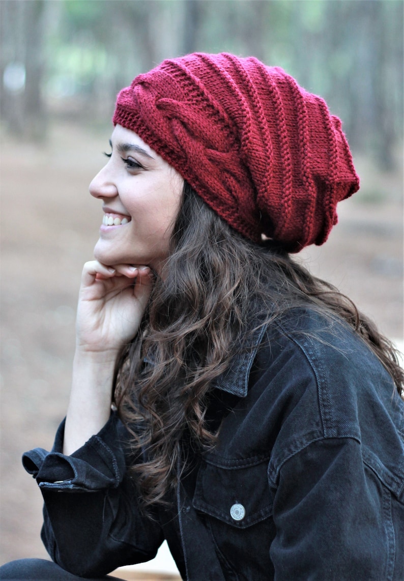 May include: A red knitted beanie with a cable knit pattern.