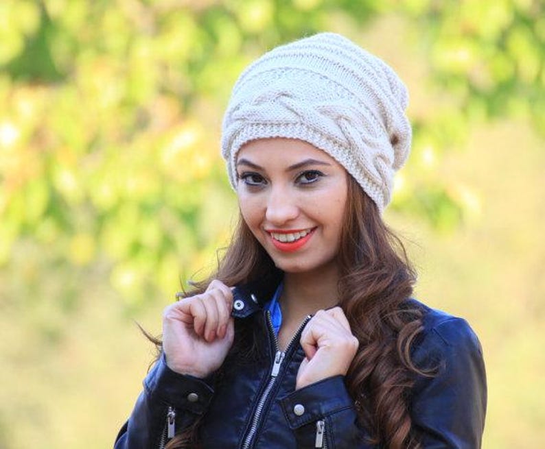 Pode incluir: Um gorro de malha de cabo creme. O chap&eacute;u tem um design texturizado e tecido e &eacute; feito de um material macio e quente. Este gorro &eacute; um acess&oacute;rio elegante para o frio e pode ser combinado com v&aacute;rias roupas.