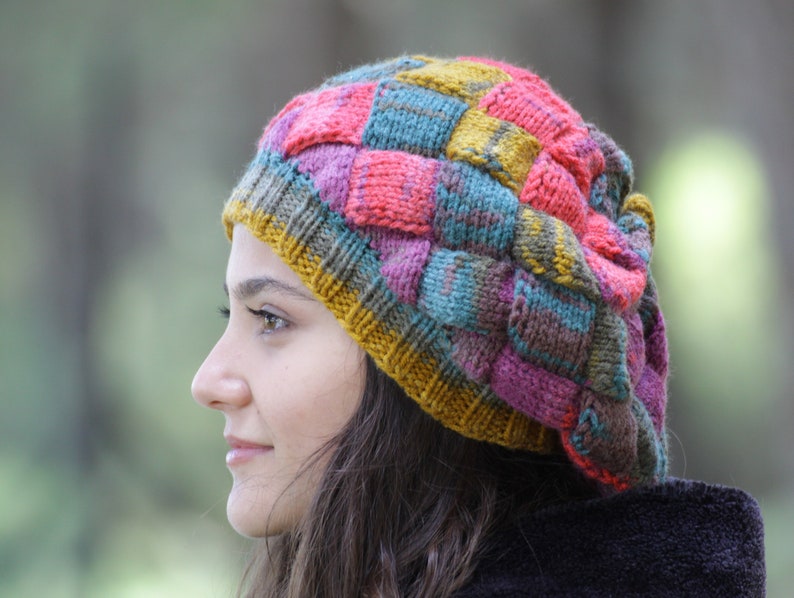 May include: A colourful knitted beanie with a patchwork design in shades of pink, blue, green, and yellow.