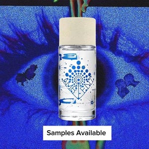 May include: A clear glass perfume bottle with a cylindrical shape and a light beige cap. The label features blue graphic designs, including starbursts and the text AMBIENT, along with the volume 50ml / 1.7 FL OZ printed on the front surface.