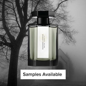 May include: A rectangular perfume bottle with a black cap and a white label. The bottle is filled with a light green liquid. The background is a black and white image of a tree and a building. Text on the label reads "PASSAGE D'ENFER EAU DE TOILETTE".