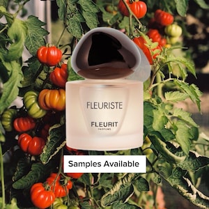 May include: A perfume bottle with a dark brown cap and a light pink body, with the word "FLEURISTE" printed on the front. The bottle is set against a backdrop of tomato plants with red and green tomatoes. The text "Samples Available" is also visible.