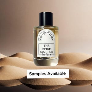 May include: A clear glass perfume bottle with a black cylindrical cap and a white label. The label features the text NONFICTION, THE BEIGE, 100ML - 3.3 FL OZ, and Perfume. Below the bottle, a white rectangular sign displays the text Samples Available.