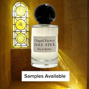May include: A clear glass perfume bottle with a black spherical cap. The label reads "Chapel Factory HOLY STICK Eau de Parfum." The background features a stained-glass window and the text "Samples Available."
