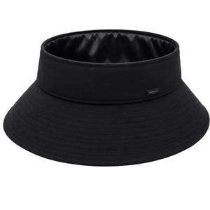 Könnte beinhalten: Ein einfarbiger schwarzer Visor mit breiter, kreisförmiger Krempe und strukturierter Krone. Das Innere ist mit einem glatten, satinartigen schwarzen Stoff ausgekleidet. Ein kleines rechteckiges schwarzes Etikett mit weißem Text ist seitlich angebracht.