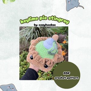 May include: A plush crochet stingray shaped like a key lime pie with a tan crust, light green filling, and a white whipped cream topping. The text reads keylime pie stingray by cozyhookss and PDF crochet pattern on a dark green circle.