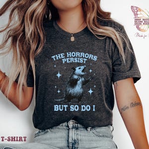 Horrors Persist But So Do I shirt, Raccoon shirt, Trendy Shirts, depression anxiety, Meme Shirt, oppossum tshirt, Funny Graphic Shirt, funny