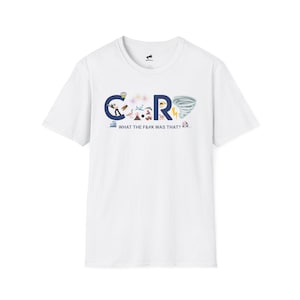 May include: White t-shirt with a graphic design featuring the letters "C" and "R" in blue, with various illustrations inside the letters. The text "WHAT THE F&@K WAS THAT?" is printed below the letters.
