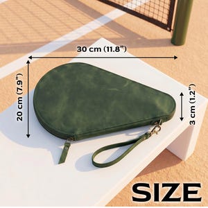 May include: A dark green, teardrop-shaped zippered case with a wrist strap. The case measures 11.8 inches in length, 7.9 inches in width, and 1.2 inches in depth. The surface has a matte, slightly textured finish with visible stitching along the edges.