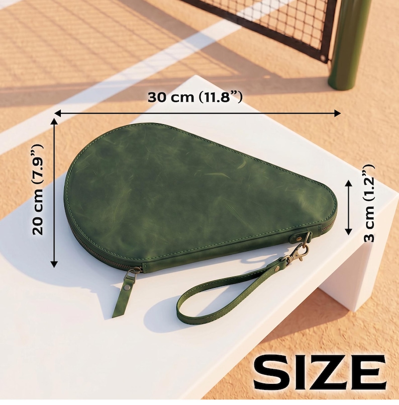 May include: A dark green, teardrop-shaped zippered case with a wrist strap. The case measures 11.8 inches in length, 7.9 inches in width, and 1.2 inches in depth. The surface has a matte, slightly textured finish with visible stitching along the edges.