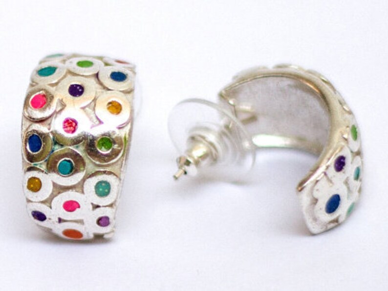 May include: Silver hoop earrings with a colorful circle pattern. The circles are filled with different colors, including pink, blue, green, and yellow.