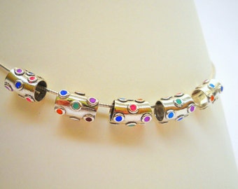 May include: Silver bracelet with colorful enamel dots. The bracelet is made of metal and has a chain link design. The dots are in various colors, including red, blue, green, and pink.