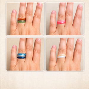 May include: A collection of four panels showing fingers wearing various silicone rings. The top left shows orange, brown, and green rings. The top right shows two pink rings. The bottom left shows light blue, silver, and dark blue rings. The bottom right shows beige and white rings.