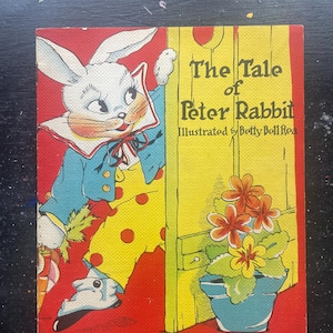 May include: A vintage children's book titled "The Tale of Peter Rabbit" with an illustration of a white rabbit in a blue jacket and yellow polka-dot pants. The cover features a red background and a flower pot.