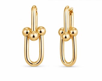Gold studded U-shaped dangle earrings, eye-catching linked earrings.