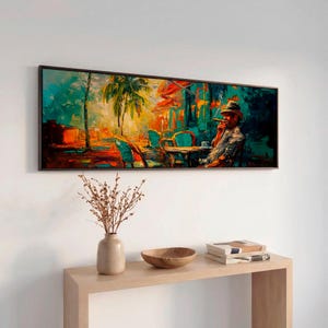 May include: A framed oil painting depicts a man smoking a cigar at an outdoor cafe. The artwork features vibrant colors, including teal, orange, and yellow, with palm trees and cafe tables. The painting is displayed above a wooden console table.