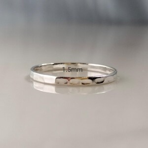 May include: A silver ring with a hammered texture. The ring is 1.5mm wide. The ring is a simple band design.