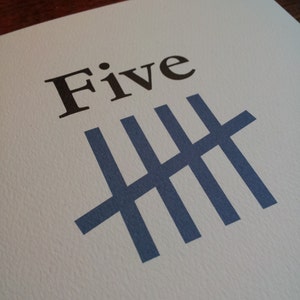 May include: A white card with the word "Five" printed in black and a blue tally mark graphic representing the number five.