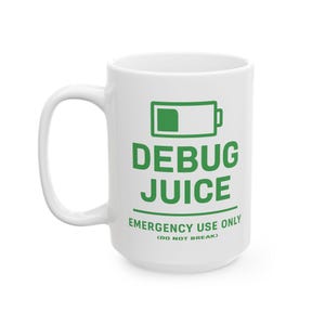May include: White ceramic mug with a large handle. The mug features green text and a battery icon that reads "DEBUG JUICE EMERGENCY USE ONLY (DO NOT BREAK)". The mug is designed for computer programmers and software developers.