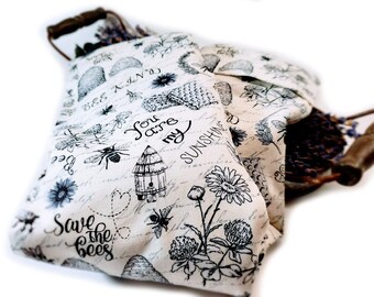 May include: Two white fabric bags with black bee and flower designs. The bags have the text "Save the Bees" and "You are my sunshine" printed on them.
