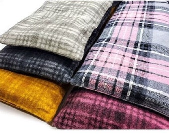 Puede incluir: Cuatro fundas de cojín de tela con diferentes patrones. Las fundas están apiladas una encima de la otra. La funda superior es de color gris claro con un patrón de cuadros blancos. La segunda funda es de cuadros rosa y gris. La tercera funda es de color gris oscuro con un patrón de cuadros blancos. La funda inferior es de color amarillo mostaza sólido.