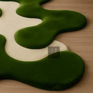 May include: A modern, abstract rug with a unique, organic shape. The rug features a contrasting color scheme with a deep green, plush texture and a creamy white, creating a visually appealing design. The rug's design adds a touch of contemporary style to any space.